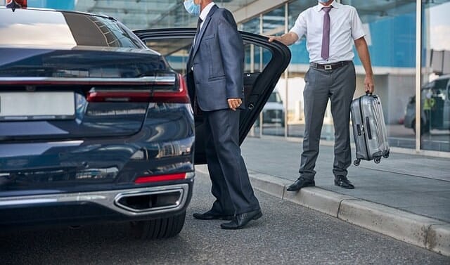 Picture of chauffeur in front of taxi at the airport